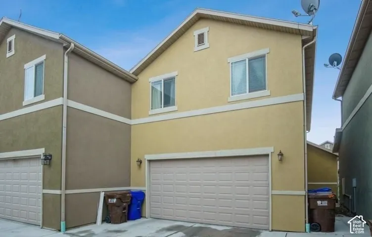 Two-story exterior with stucco finish, white trim accents, and attached garage