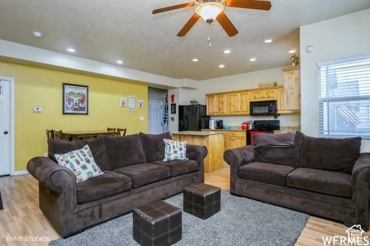 Open-concept living space featuring wood-finish flooring, recessed lighting, and a ceiling fan