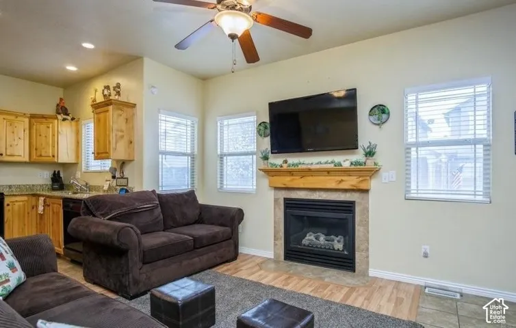 Wood-finish flooring with a gas fireplace featuring a tile surround and wood mantel