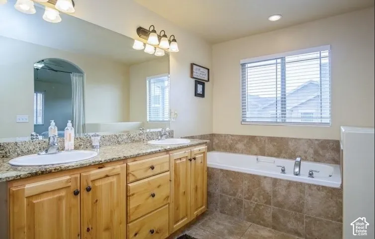 Dual vanity with light wood cabinetry and stone-finish countertops