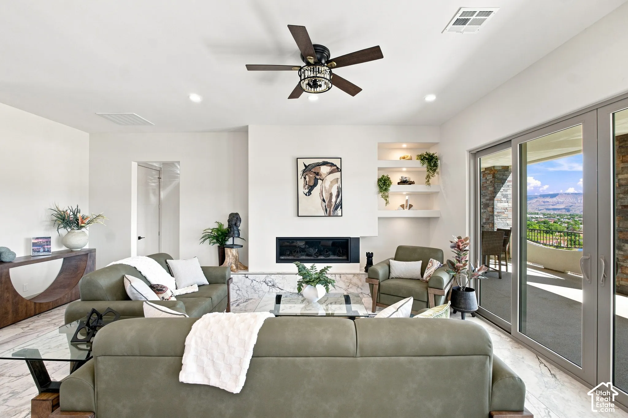 Living area featuring white walls, recessed lighting, a ceiling fan, and a built-in fireplace with a stone surround