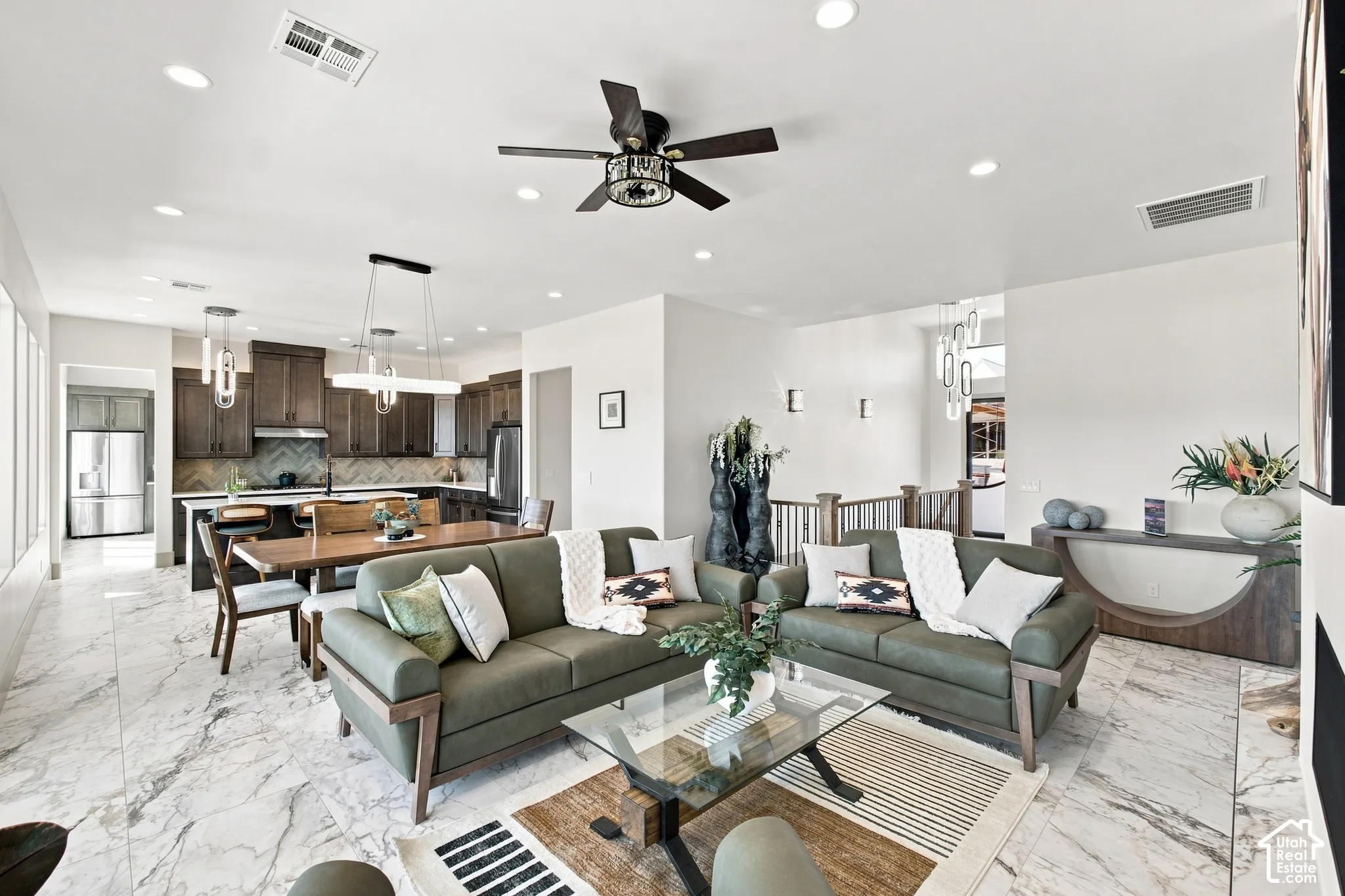 Open-concept living space with large format marble-look tile flooring, recessed lighting, and a ceiling fan
