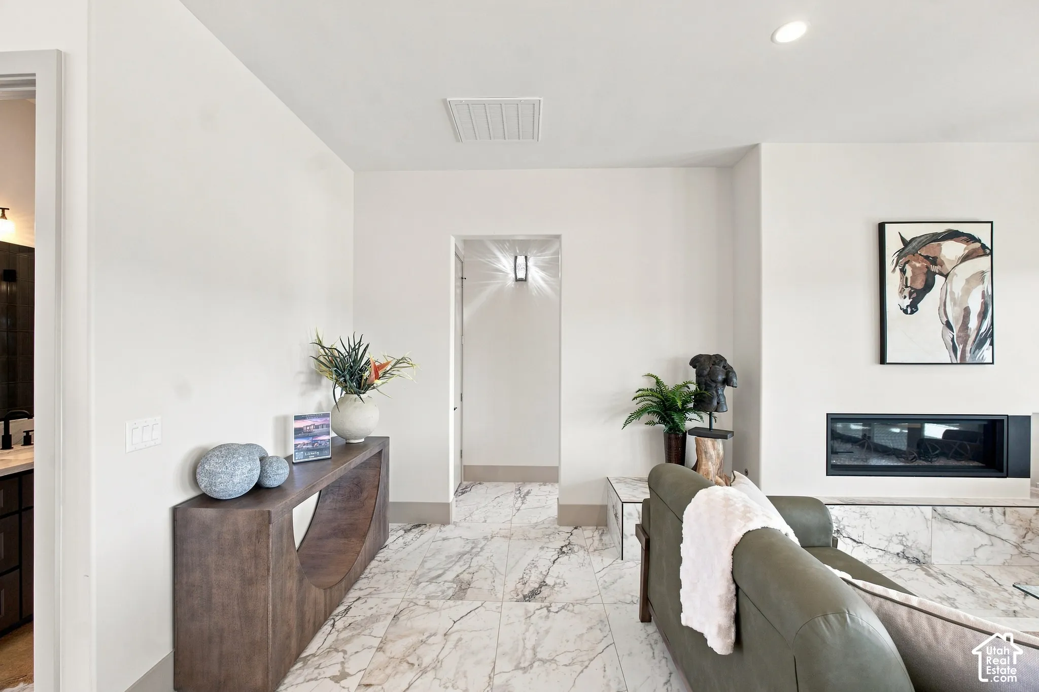 Marble-look tile flooring, built-in linear fireplace, recessed ceiling lighting, and solid core doors