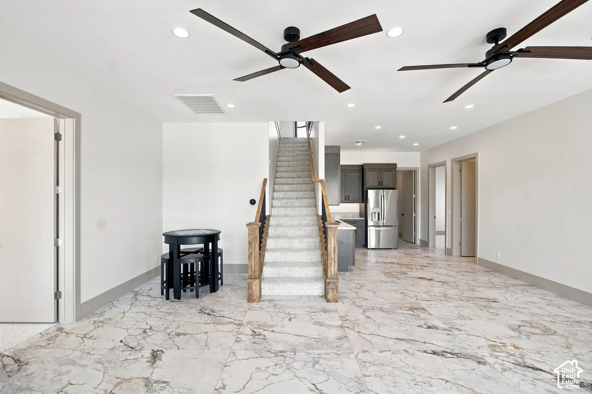 Open concept living area featuring large format tile flooring, recessed lighting, and modern ceiling fans