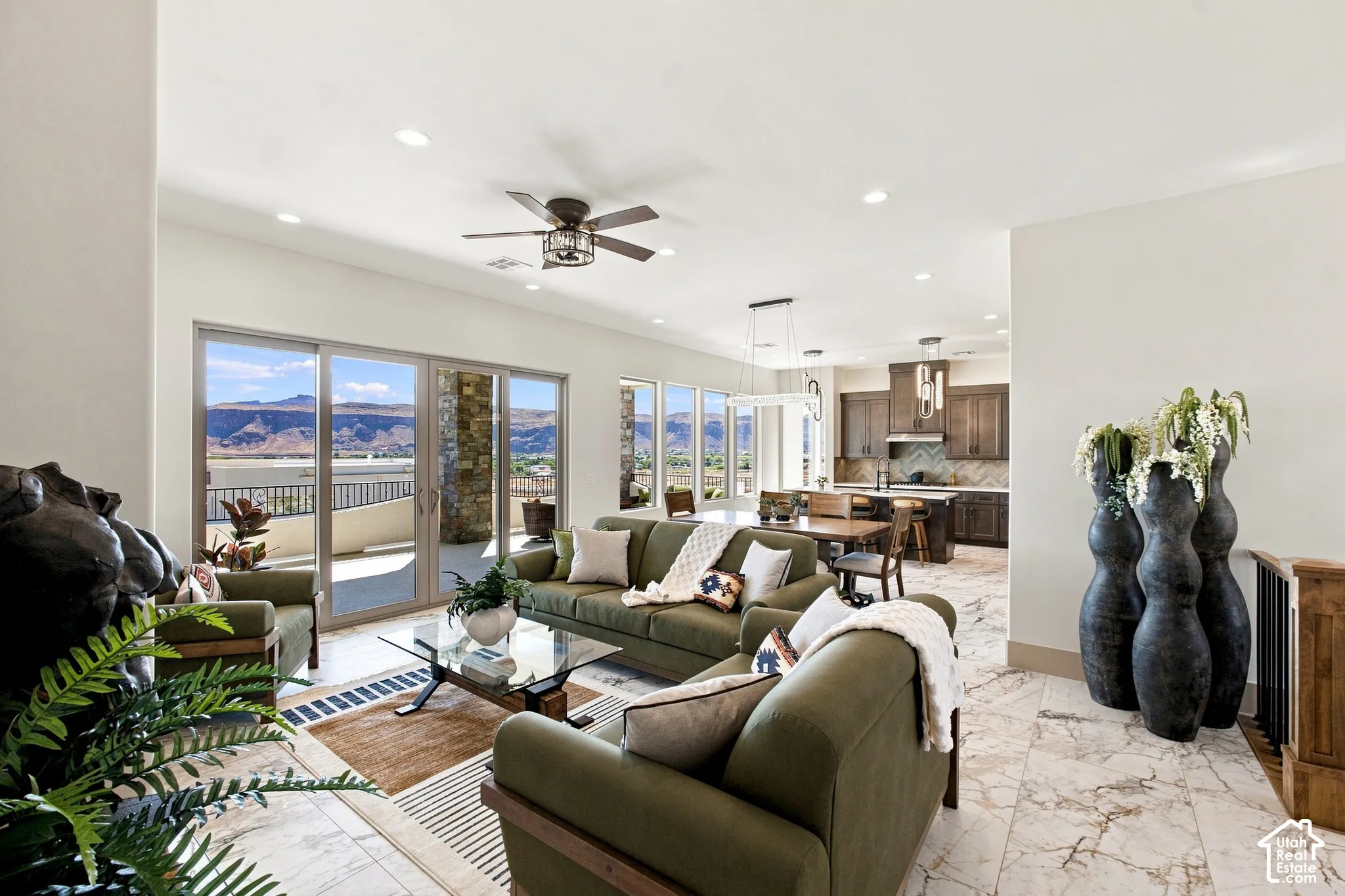 Open-concept living area with large format tile flooring, recessed lighting, and a ceiling fan