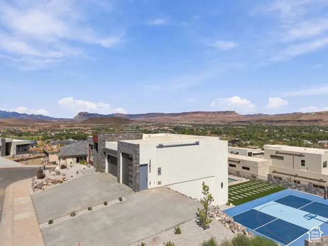 Contemporary exterior with stone veneer accents, multi-car driveway, and integrated sport court
