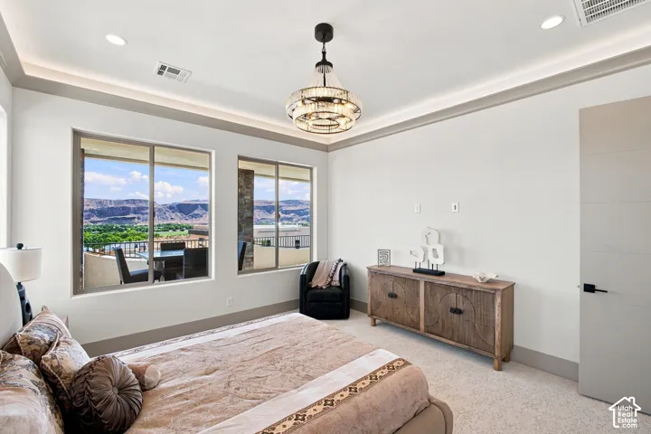 Recessed lighting, crown molding, and a decorative chandelier illuminate the space