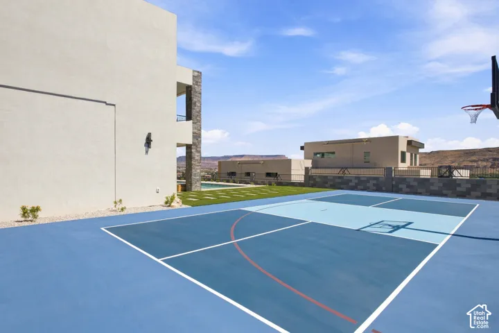 Multi-use outdoor court with blue and light blue surfacing, white court lines, and a basketball hoop
