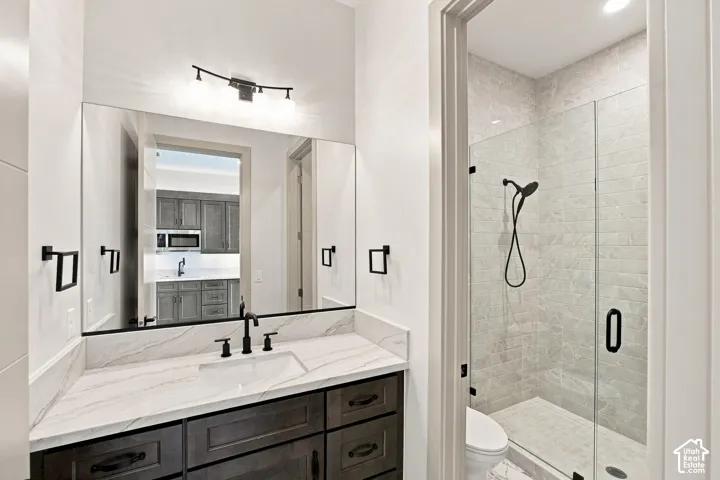 Vanity with an integrated rectangular sink, matte black faucet, and stone-finish countertop
