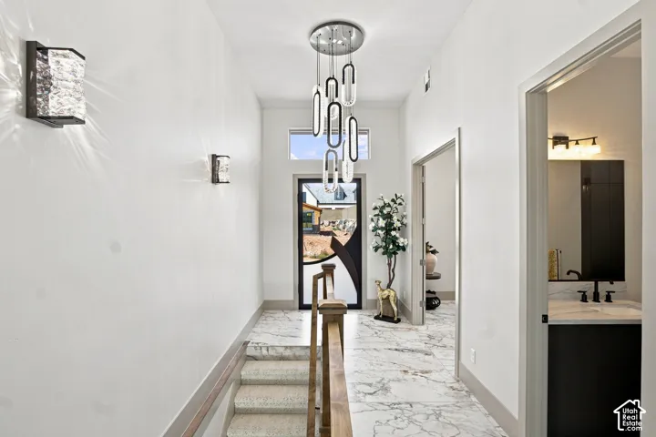 Foyer featuring a contemporary chandelier, recessed lighting, and stone-finish flooring