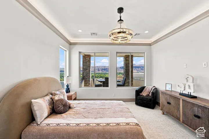Recessed lighting, crown molding, and tray ceiling with a chandelier