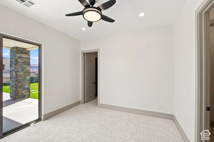Recessed lighting, ceiling fan, carpeting, sliding glass patio door, and stone column exterior accent