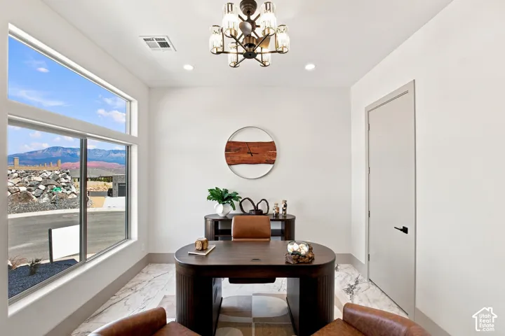 Recessed lighting and a chandelier illuminate the space