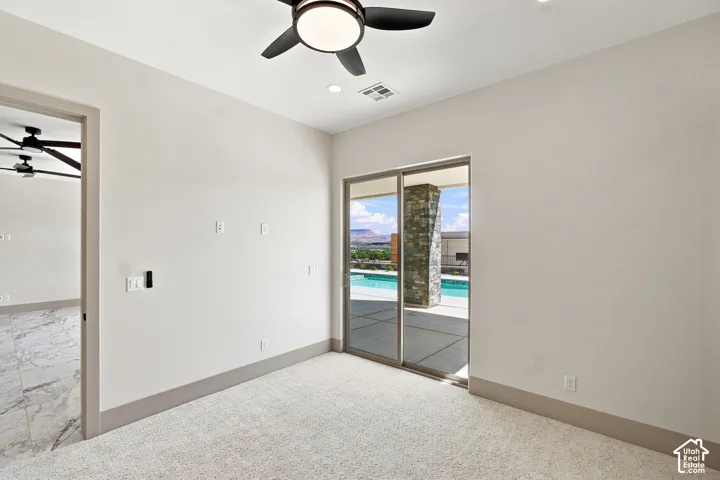 Dual ceiling fans, recessed lighting, sliding glass doors, pool access, and stone-clad exterior columns