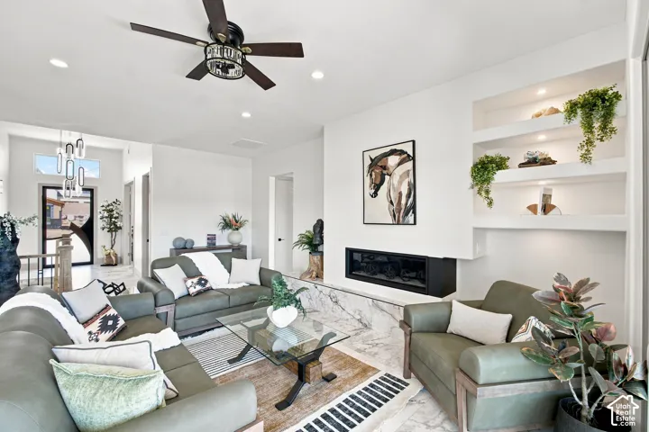 Bright, open living area showcasing white shiplap walls, recessed ceiling lighting, and a ceiling fan with industrial detailing
