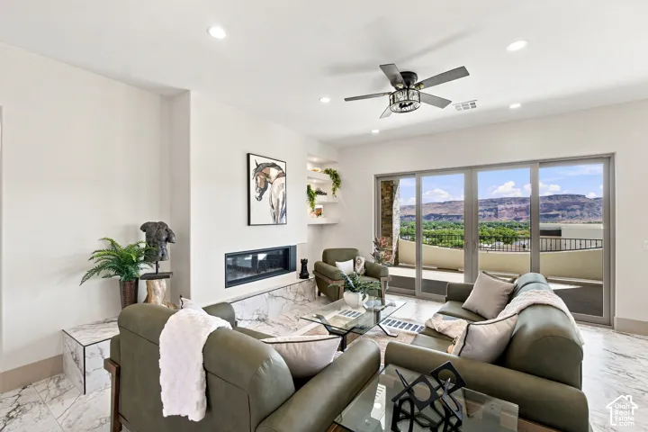 Spacious living area featuring marble-finish flooring, a linear electric fireplace, and recessed lighting