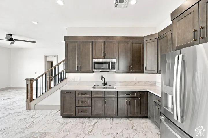 Built-in wet bar with wood-finish cabinetry, stainless steel appliances, and a solid surface countertop
