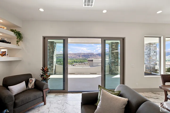 Sliding glass doors opening to an outdoor patio with mountain scenery