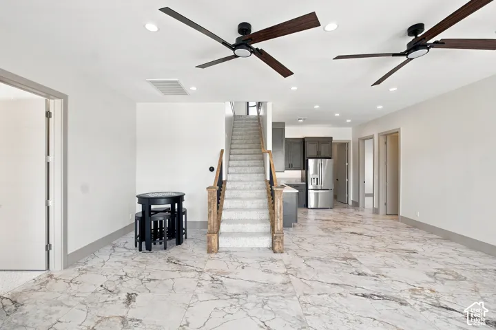 Open concept living area featuring large format tile flooring, recessed lighting, and modern ceiling fans
