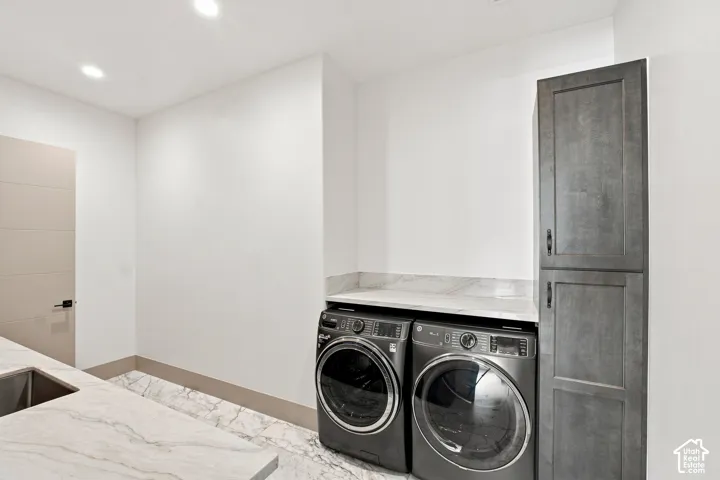 Laundry area with integrated sink, stone countertops, and built-in storage cabinetry