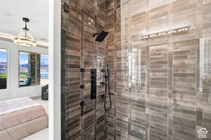 Spacious shower featuring full-height tiled walls, glass enclosure, and matte black fixtures