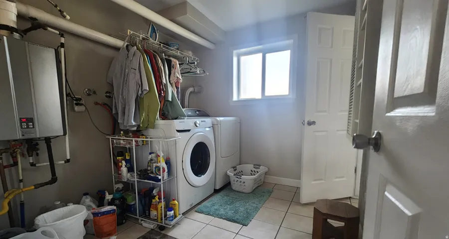 Spacious laundry room with plenty of storage and on demand water heater.