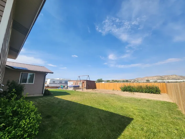 Spacious backyard featuring a substantial lawn area with full auto-sprinklers, full privacy fencing and direct sprinklers to garden area.