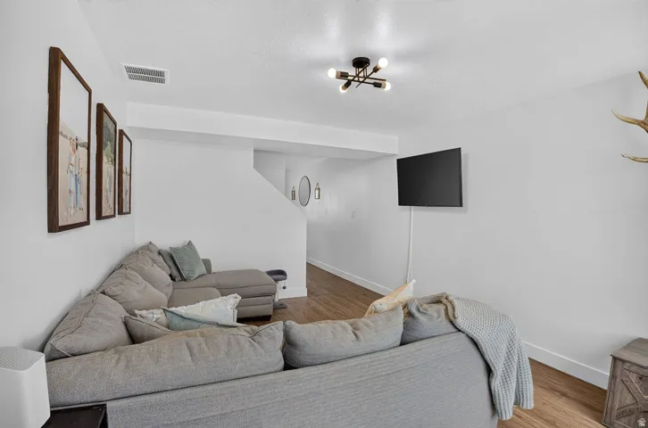 Open living area featuring wood-finish flooring and a contemporary ceiling light fixture