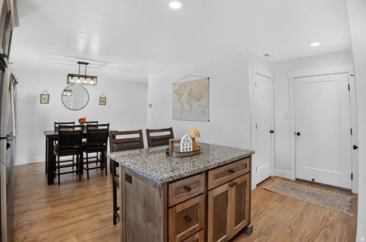 Kitchen island featuring a stone-look countertop, wood-finish cabinetry, and integrated seating