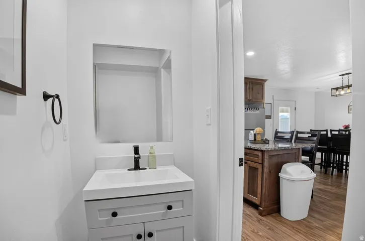 Powder room with a modern vanity, integrated sink, matte black faucet, and rectangular mirror
