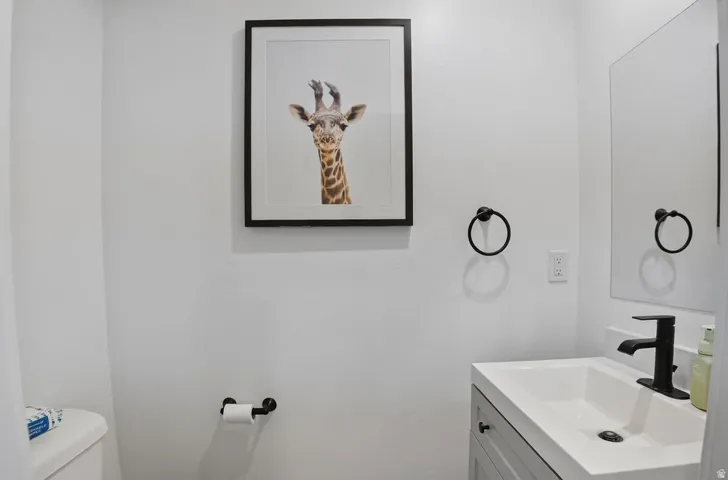 Bathroom featuring a contemporary vanity with an integrated sink, matte black faucet, and coordinating towel ring