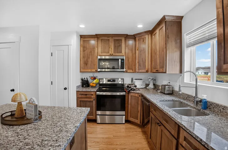Kitchen featuring wood-finish cabinetry, speckled countertops, and stainless steel appliances