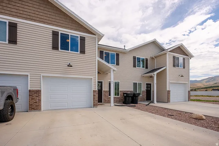 Multi-unit exterior with beige horizontal siding and brown shingle accents