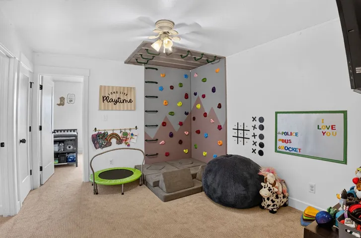 Built-in climbing wall featuring colorful holds and a padded base