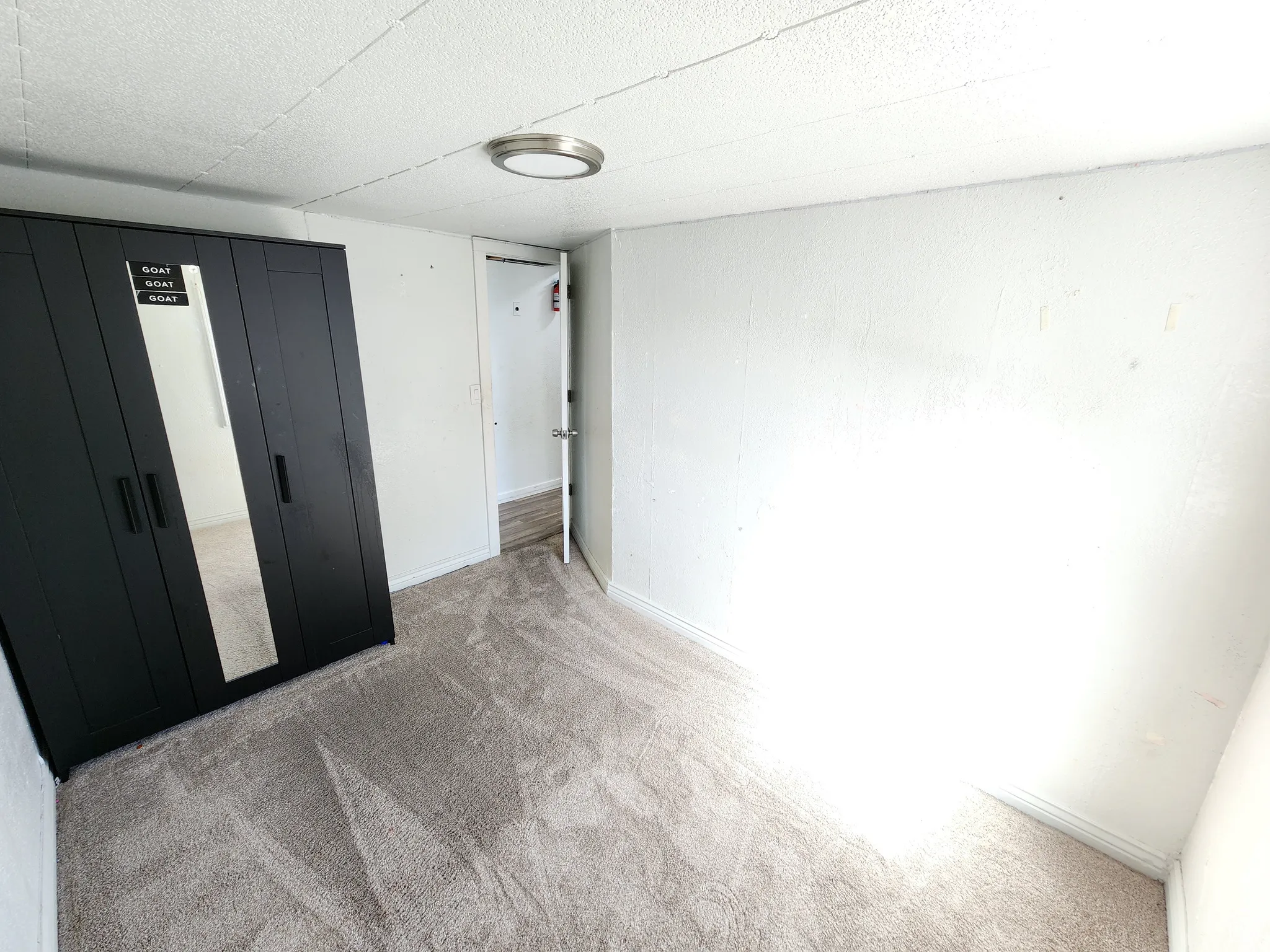 Room featuring light-colored carpeting and white walls