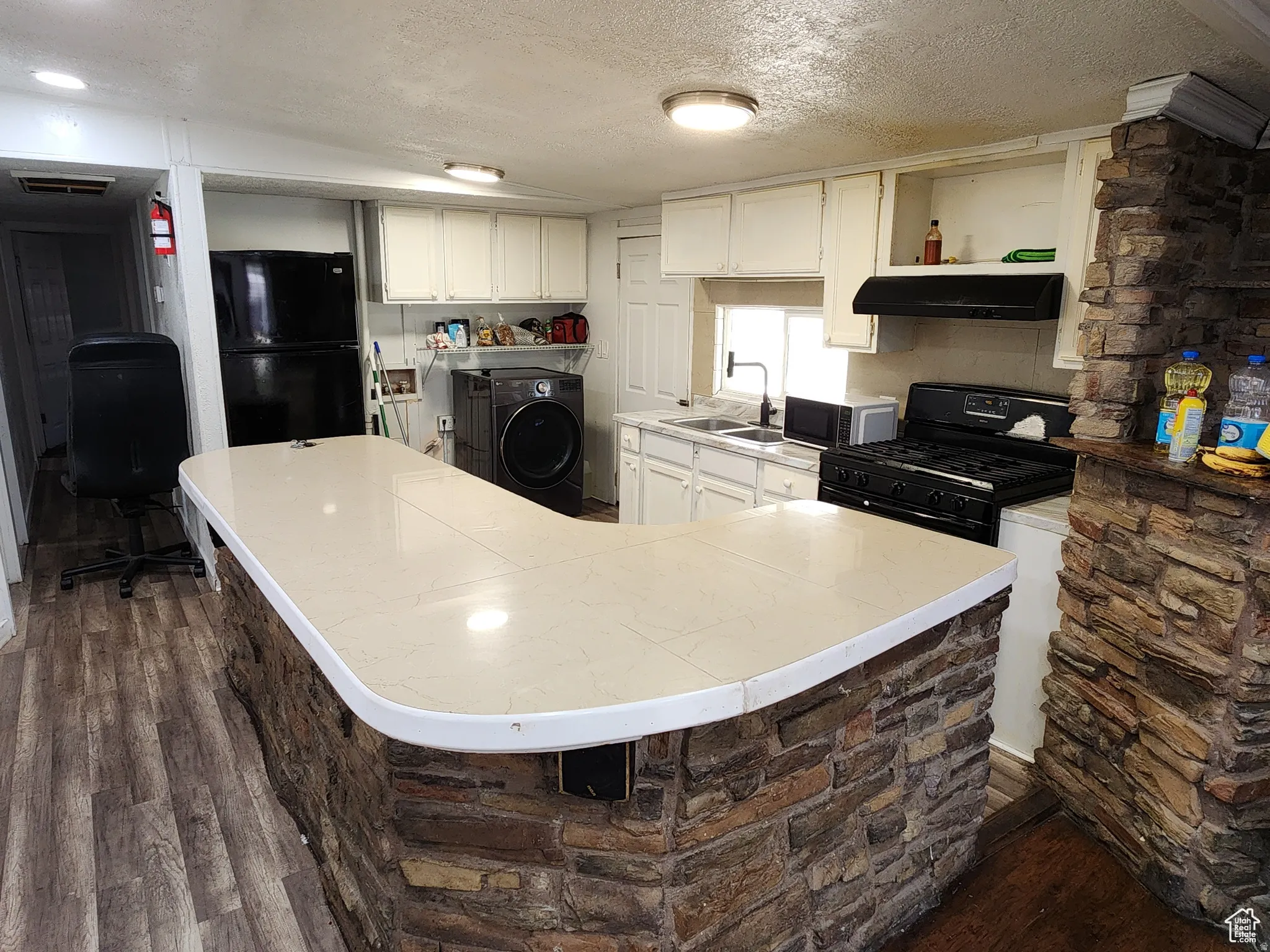 Stone-clad kitchen island with a light-toned countertop
