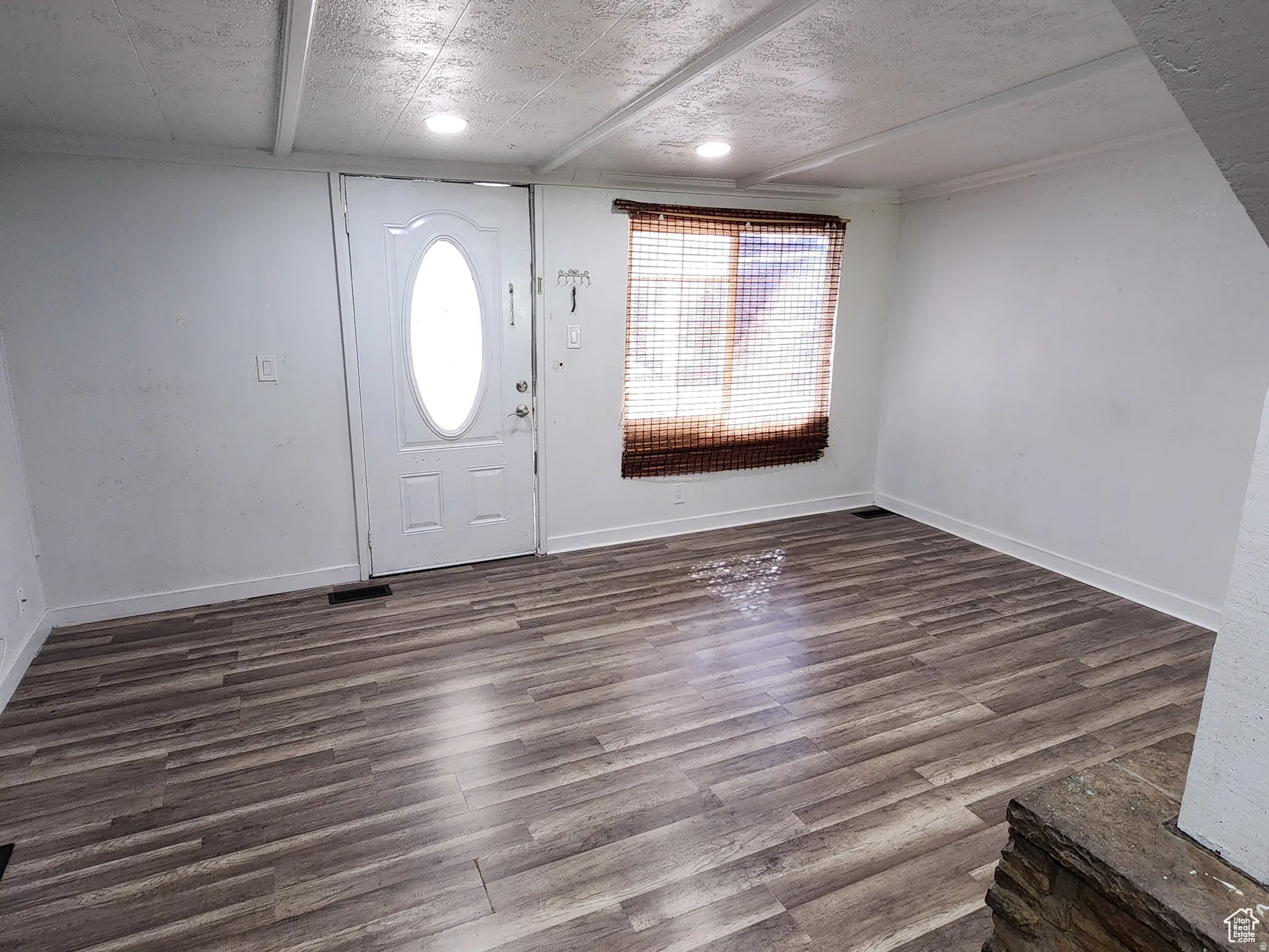 Entryway featuring wood-finish flooring and a white paneled door with an oval glass insert