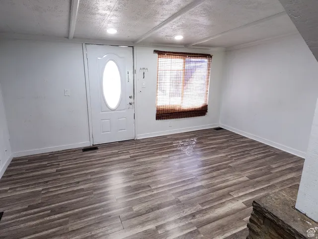 Entryway featuring wood-finish flooring and a white paneled door with an oval glass insert