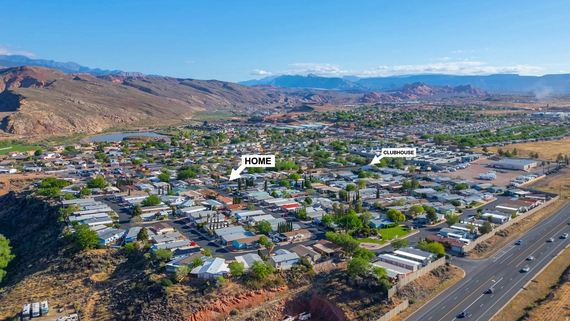 Expansive aerial perspective showcasing a residential community with a large body of water and distant mountainous terrain