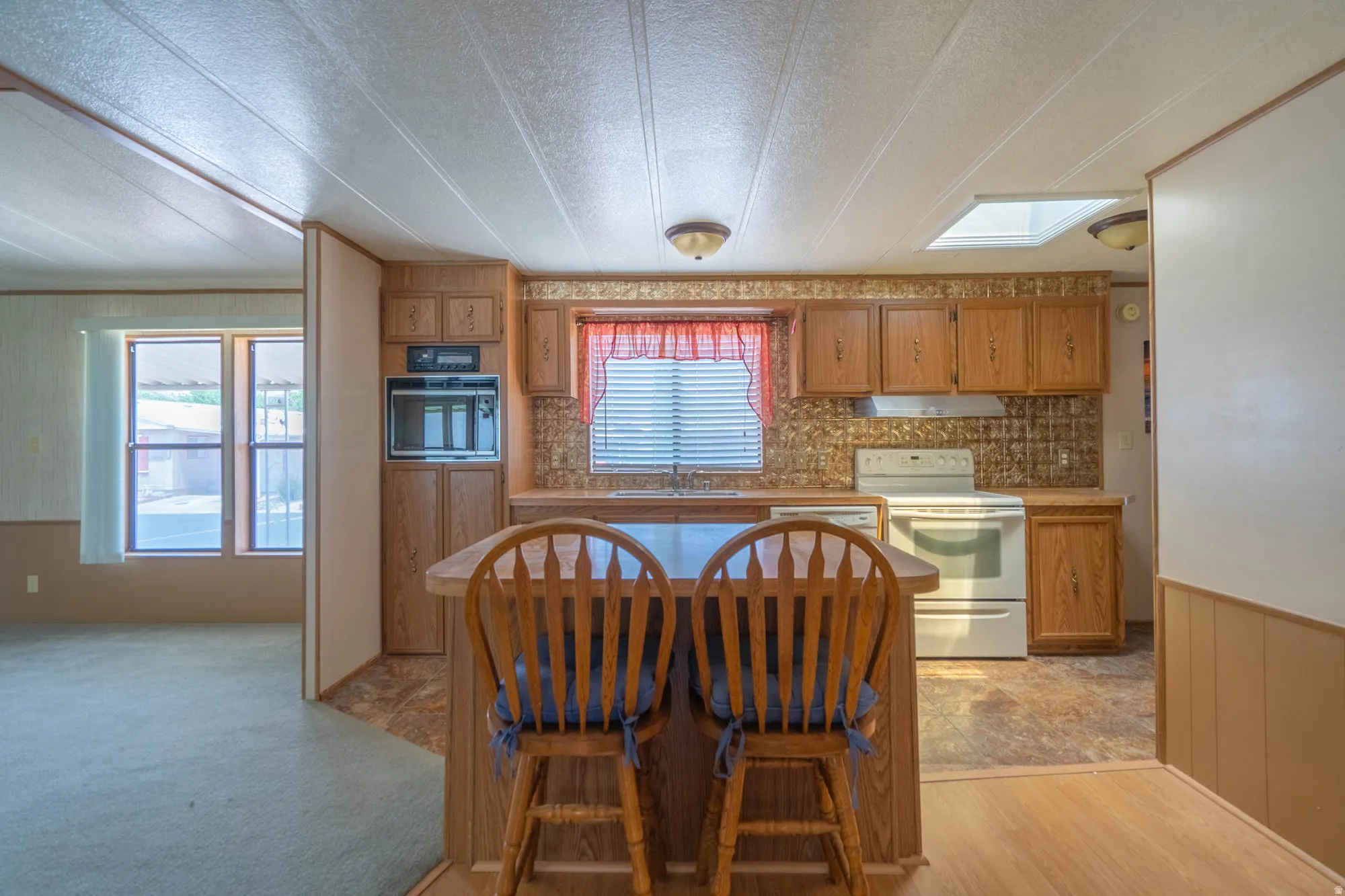 Kitchen featuring wood-finish cabinetry, white appliances, and a built-in oven