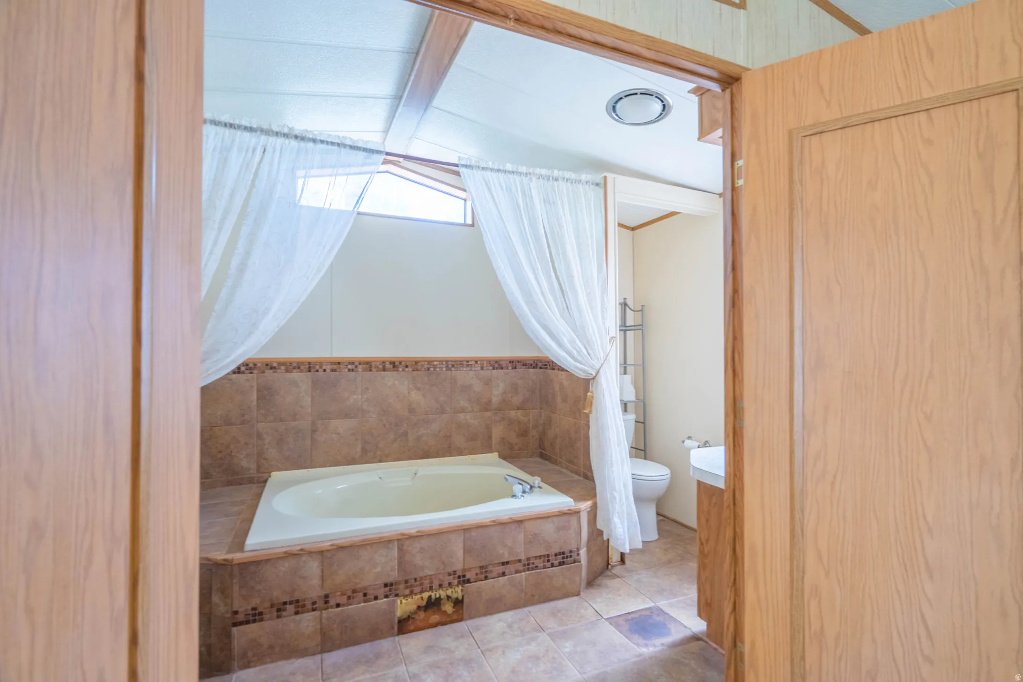 Soaking tub set in a tiled surround with a decorative mosaic border