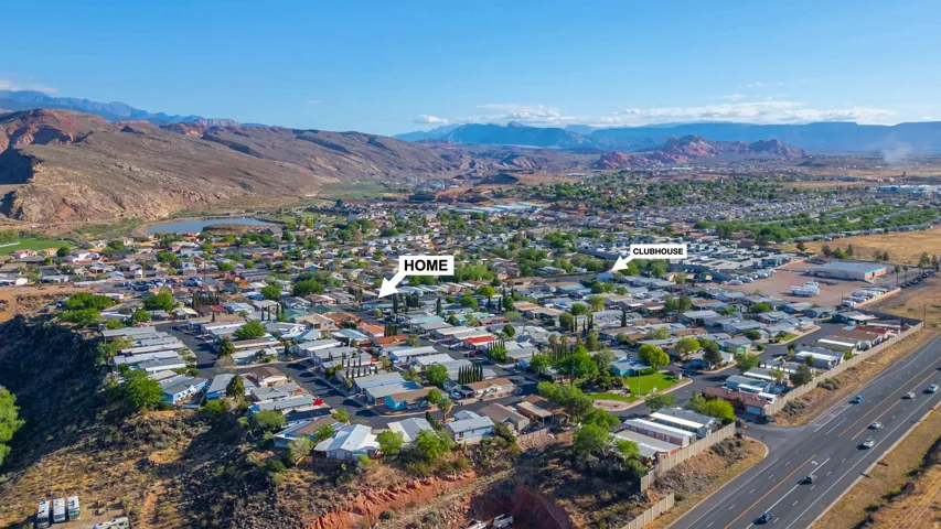 Expansive aerial perspective showcasing a residential community with a large body of water and distant mountainous terrain