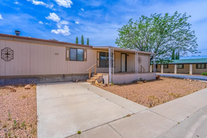 Exterior featuring a covered front porch, concrete driveway, and a partially landscaped front yard