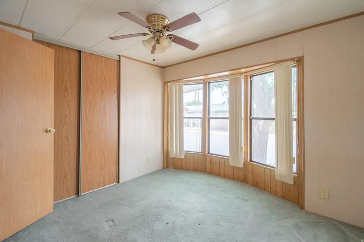 Bay window with vertical blinds and wood-finish paneling