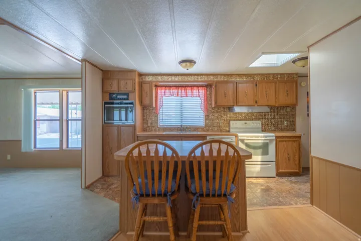 Kitchen featuring wood-finish cabinetry, white appliances, and a built-in oven