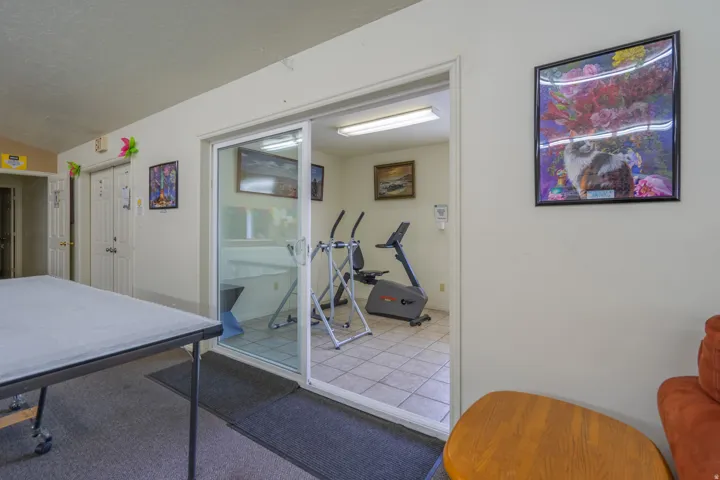 Fitness area with tiled flooring accessed through sliding glass doors