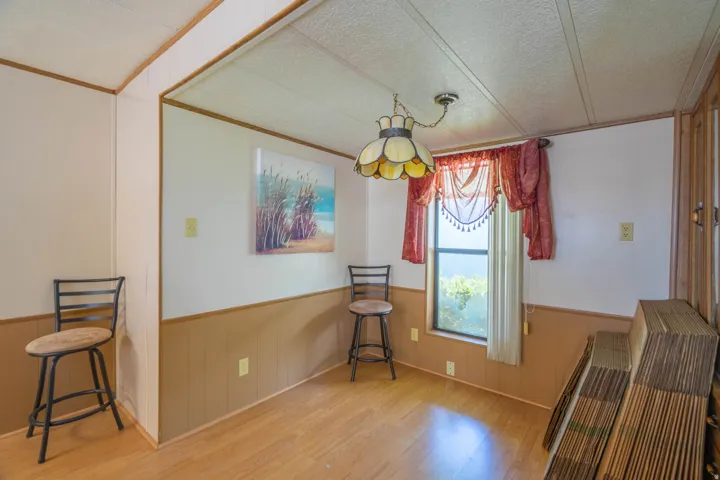 Interior space featuring wood-finish flooring, two-tone wall paneling, and a single window
