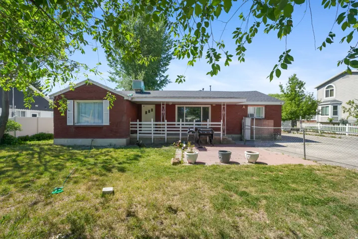 Red brick exterior residence featuring a front lawn and a covered porch