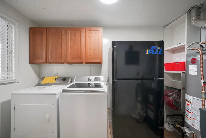 Dedicated laundry area featuring overhead wood cabinetry and built-in shelving