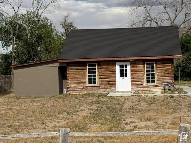 Log cabin exterior with a dark asphalt shingle roof